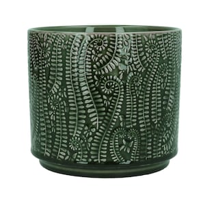 May include: A cylindrical ceramic planter in a deep forest green hue, featuring a raised, textured pattern of swirling fern fronds across its exterior surface. The pot has a smooth, glossy finish and a distinct stepped base design.