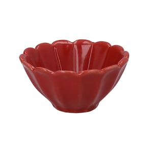 May include: A small, glossy red ceramic bowl with a scalloped, flower-like rim. The bowl features vertical ridges along its interior and exterior walls, creating a petal-shaped silhouette that tapers down to a rounded base against a white background.