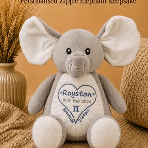 Könnte beinhalten: Ein graues und weißes Plüschelefant-Spielzeug mit einer Stickerei auf dem Bauch, die Royston, 30th May 2026, 3 pounds, 2:24pm sowie ein Zwillinge-Sternzeichen in einem blauen Herzumriss zeigt. Der Elefant hat große Ohren und einen Rüssel.