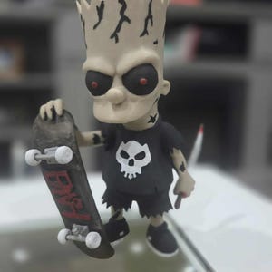 May include: A figurine of a zombie-like Bart Simpson holding a skateboard. The figure has a pale complexion, black eyes with red pupils, and a black t-shirt with a white skull. The skateboard is black with red lettering.