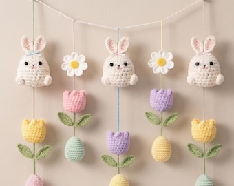 May include: A decorative Easter garland with crocheted elements. It features white bunnies, daisies, and colourful tulips and eggs in pastel shades. The garland is suspended from a white string, creating a charming, handmade decoration for the home.