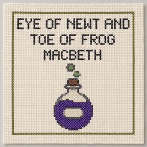 May include: A cross-stitch embroidery on cream fabric featuring the black text EYE OF NEWT AND TOE OF FROG MACBETH above a potion bottle graphic. The bottle has a brown cork, a purple liquid body, and two small green bubbles floating above it.