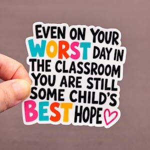 May include: A white sticker with the text "EVEN ON YOUR WORST DAY IN THE CLASSROOM YOU ARE STILL SOME CHILD'S BEST HOPE" in various colors. A pink heart is at the end of the text.