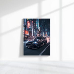 May include: A framed print featuring a dark gray sports car speeding down a city street at night. The car's headlights are on, and the background shows illuminated buildings with Japanese text.