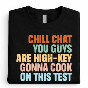 May include: Black sweatshirt with the text "CHILL CHAT YOU GUYS ARE HIGH-KEY GONNA COOK ON THIS TEST" in orange, green, yellow, pink, and blue. The sweatshirt is folded neatly.