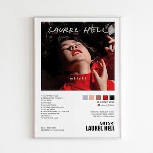 May include: A framed poster featuring the album art for Mitski's "Laurel Hell." The image shows a person with red lipstick and a red top. The album title and artist name are displayed, along with the tracklist and release information.