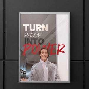 Könnte beinhalten: Gerahmtes Poster mit dem Text "TURN PAIN INTO POWER" in Weiß und Rot. Das Bild zeigt eine Person, die einen durchsichtigen Regenmantel trägt. Das Poster wird an einer schwarzen Wand angezeigt.