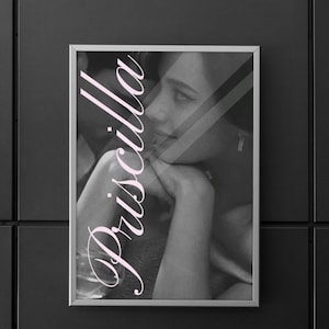 Puede incluir: Fotografía en blanco y negro enmarcada con una mujer, con el nombre "Priscilla" en escritura rosa superpuesta. La mujer apoya la barbilla en la mano. La imagen se muestra detrás de una superficie reflectante.