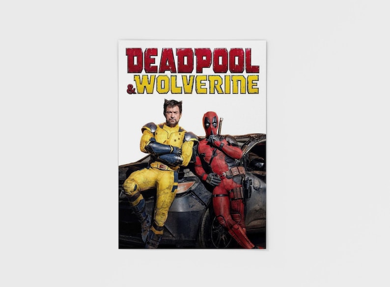 Puede incluir: Un p&oacute;ster con los personajes Deadpool y Wolverine. El t&iacute;tulo "DEADPOOL & WOLVERINE" est&aacute; en rojo y amarillo. Wolverine lleva un traje amarillo y Deadpool un traje rojo, ambos apoyados en un coche.