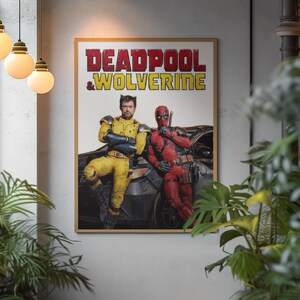 Puede incluir: Un p&oacute;ster enmarcado con los personajes Deadpool y Wolverine. El texto del t&iacute;tulo es rojo y amarillo. Wolverine lleva un traje amarillo y azul, y Deadpool un traje rojo. El p&oacute;ster se muestra en una pared gris.