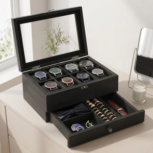 May include: A black wooden watch box with a glass lid, featuring eight watch compartments containing various wristwatches. A pull-out drawer below contains a dark blue bow tie, multiple rings arranged in rows, and a brown leather watch strap.