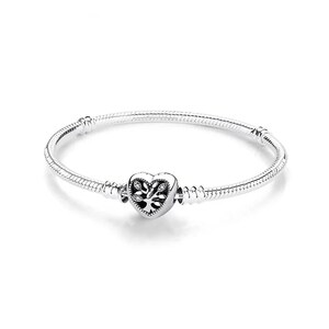 May include: A silver snake chain bracelet featuring a heart-shaped charm in the center. The charm displays an intricate tree of life design with small embedded clear stones. The bracelet includes two fixed stations along the chain for charm placement.
