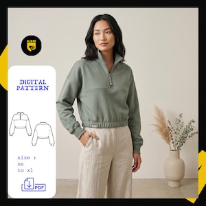 Peut inclure: Un sweat-shirt vert sauge à fermeture éclair quart, manches longues, col montant et ourlet côtelé. L'image comprend une étiquette de patron numérique, un dessin au trait du vêtement, le texte 'DIGITAL PATTERN', 'size: xs to xl' et une icône PDF.