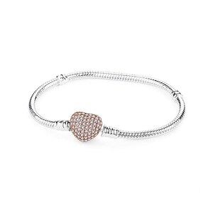 May include: A silver snake chain bracelet featuring a central heart-shaped charm. The heart charm is rose gold in color and is covered in numerous small, clear, sparkling stones. The bracelet has a smooth, flexible, metallic link construction.