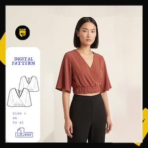 Peut inclure: Un chemisier cache-cœur court de couleur rouille avec un décolleté en V, des manches courtes larges et une taille élastiquée froncée. L'image inclut une étiquette de patron numérique avec le texte ILEM, DIGITAL PATTERN, size: xs to xl et une icône PDF.