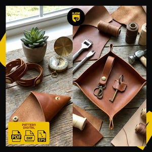 May include: A collection of handcrafted leather goods and tools, including a tray, keychains, bracelets, and a pouch. The image also features a succulent plant, a compass, and spools of thread, all arranged on a wooden surface.