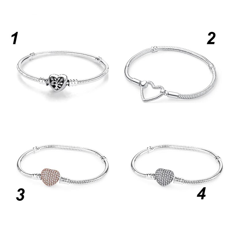 May include: Four silver-tone snake chain bracelets labeled 1 through 4. Bracelet 1 features a heart charm with a tree design. Bracelet 2 has a heart-shaped clasp. Bracelet 3 includes a rose gold-tone pav&eacute; heart charm. Bracelet 4 has a silver-tone pav&eacute; heart.