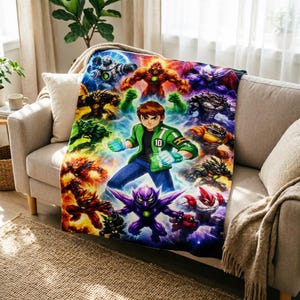 Peut inclure: Une couverture jeté rectangulaire présentant une illustration centrale du personnage Ben 10 portant une veste verte avec un emblème numéro 10, entouré d'un collage vibrant de diverses créatures extraterrestres colorées sur un fond d'énergie bleu.