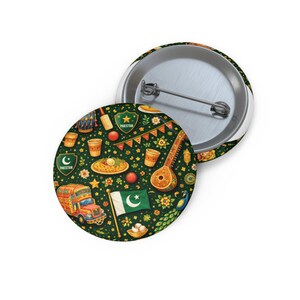 May include: Two round pinback buttons with a green background featuring a pattern of Pakistani cultural elements. The design includes a flag, food, musical instruments, and a decorated truck. One button is open, showing the pin.