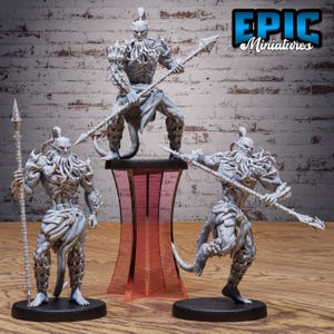 May include: Three grey unpainted fantasy miniature figures featuring humanoid creatures with tentacle-like facial features, muscular builds, and textured leg armour. Each figure holds a long spear-like weapon, standing on circular black bases.