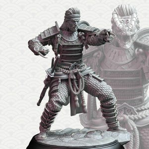 Puede incluir: Escultura gris detallada de un guerrero samurái con armadura completa, posando dinámicamente con una espada y un brazo con forma de serpiente. La figura se encuentra sobre una base texturizada, mostrando intrincados detalles de la armadura y rasgos faciales. Una segunda figura de samurái más tenue es visible en el fondo.