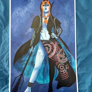 May include: A print featuring a stylized character with blue skin, orange hair, and a black hooded cloak. The character holds a spear and is set against a blue patterned background. The artwork has a fantasy theme.