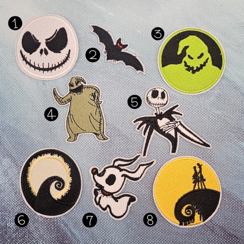 May include: A collection of eight embroidered patches featuring characters and scenes from "The Nightmare Before Christmas." Includes Jack Skellington, Zero, Oogie Boogie, a bat, and iconic imagery in black, white, green, and yellow.