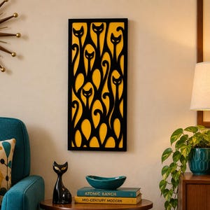 May include: A rectangular wall art piece featuring a black cutout overlay of multiple stylized cat silhouettes against a solid yellow background, framed in a thin black border. The design displays repeating feline shapes with elongated bodies and pointed ears.