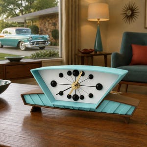 May include: A mid-century style mantle clock with a trapezoidal turquoise frame and a white face. The clock features black spherical hour markers, thin black hands, and gold-colored center hands. The base is constructed from dark brown wood.