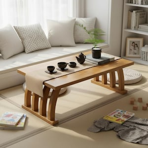 Può includere: Un tavolino rettangolare in legno chiaro. Il tavolo ha gambe curve e un runner beige. Tazze da tè, una teiera e una piccola pianta sono sopra. Il tavolo è lungo circa 76 cm.