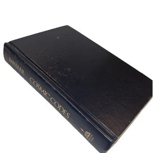 Könnte beinhalten: Ein schwarzes gebundenes Buch mit dem Titel Cosmic Codes von Chuck Missler. Der vordere Einband zeigt den Namen des Autors in schwarzer Prägung, während der Buchrücken den Titel und Autor in goldener Schrift sowie ein goldenes Koinonia House Logo.
