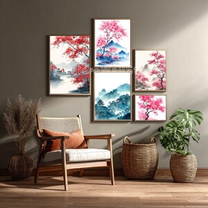Peut inclure: Ensemble d'œuvres d'art encadrées représentant des paysages japonais à l'aquarelle. Les œuvres comprennent des cerisiers en fleurs, des montagnes et des bâtiments traditionnels dans des tons de rose, de bleu et de vert. L'art est affiché au-dessus d'une chaise en bois et d'un panier.