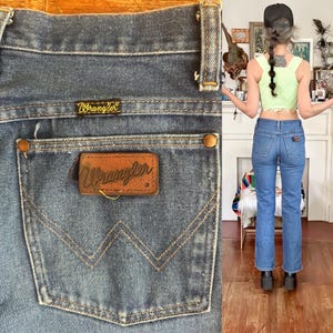 Puede incluir: Vaqueros Wrangler de mezclilla azul con un dise&ntilde;o cl&aacute;sico de cinco bolsillos. El bolsillo trasero presenta un parche de cuero marr&oacute;n con el logotipo de Wrangler. Los vaqueros tienen un corte de pierna recta y est&aacute;n hechos de mezclilla duradera.