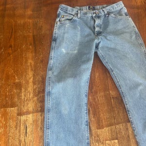 Puede incluir: Vaqueros de mezclilla azul claro con un dise&ntilde;o cl&aacute;sico de cinco bolsillos. Los vaqueros tienen cierre de bot&oacute;n y cremallera, trabillas para el cintur&oacute;n y un lavado descolorido. Los vaqueros est&aacute;n hechos de un material de mezclilla duradero.