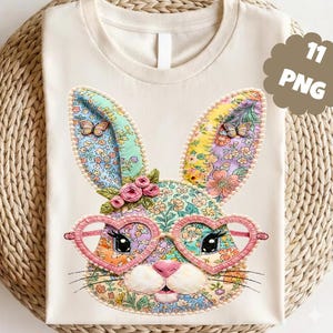 May include: Cream-colored t-shirt featuring a colorful, patchwork bunny face with heart-shaped glasses. The bunny has floral patterned ears, a pink nose, and a small floral crown. The image includes the text "11 PNG" in a brown, cloud-shaped graphic.
