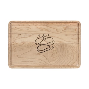 Puede incluir: Tabla de cortar rectangular de madera clara. La tabla presenta una ranura tallada alrededor de los bordes y un dibujo lineal negro de una pata de pollo, un filete y un trozo de carne. El dibujo tiene acentos brillantes.