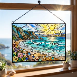 May include: A rectangular stained glass panel featuring a coastal scene with a sun, lighthouse, cliffs, and turquoise waves. The foreground displays colorful flowers and seashells. The piece is framed in black metal and hangs from a silver chain.