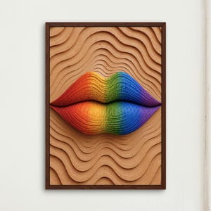 May include: A rectangular framed wall art piece featuring a three-dimensional relief of lips centered on a tan background with wavy, rippled textures. The lips display a vibrant rainbow gradient of red, orange, yellow, green, blue, and purple.