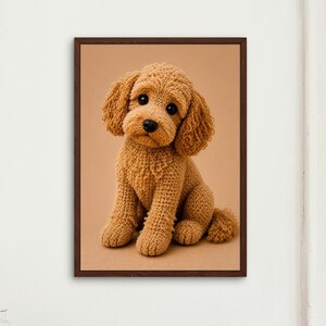 May include: A framed wall art print featuring a golden-brown crocheted puppy with a textured yarn appearance, large dark eyes, and a black nose, set against a solid tan background within a simple dark brown wooden frame.