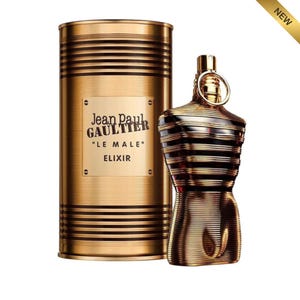 May include: A gold-toned perfume bottle and matching cylindrical container. The bottle is shaped like a torso with vertical lines and a gold ring around the neck. The container has horizontal lines and the text "Jean Paul Gaultier" and "LE MALE ELIXIR".