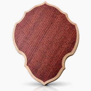 Könnte beinhalten: Holzschild in Schildform. Die Mitte ist rotbraun mit Holzmaserung, der Rand hellbeige. Das Schild hat einen dekorativen, gewellten Rand.