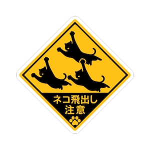 以下が含まれることがあります： 黄色いひし形のステッカー。黒い縁取りがあり、3匹の黒猫のシルエットが空中に描かれています。「ネコ飛び出し注意」の日本語と足跡のマークが描かれています。