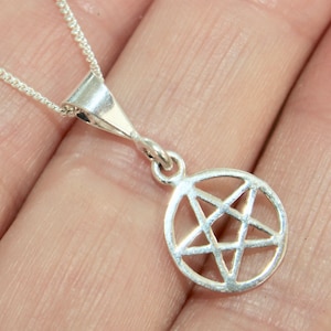 May include: Silver pendant necklace featuring a pentagram design. The pendant is a circle with a five-pointed star inside.
