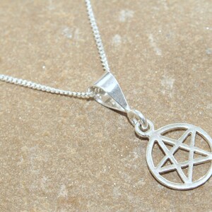May include: A silver necklace with a pendant featuring a pentagram inside a circle.