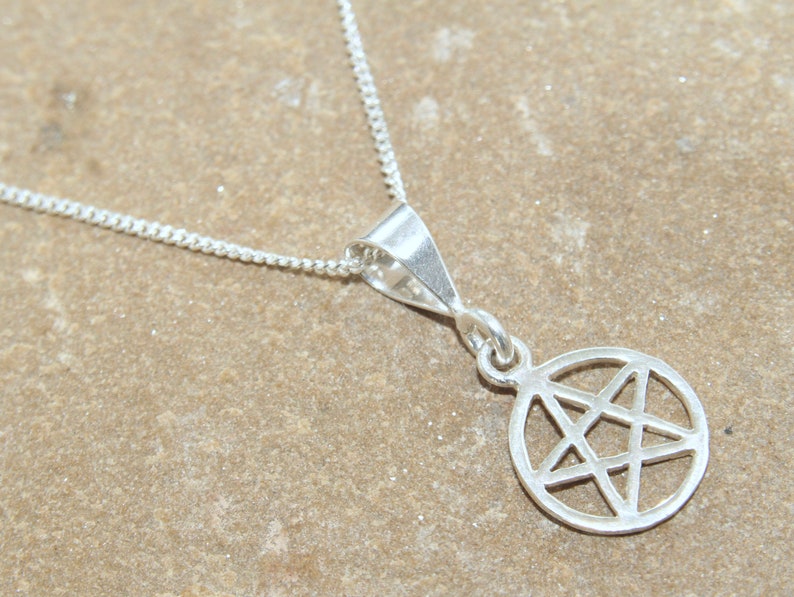 May include: A silver necklace with a pendant featuring a pentagram inside a circle.