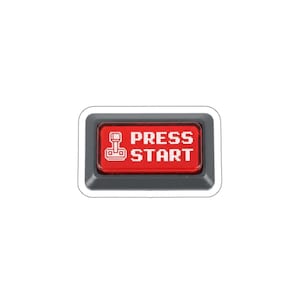 May include: A rectangular red button with the words "PRESS START" in white, and a pixelated joystick icon. The button is set in a gray frame, and is likely for a video game console or arcade machine.