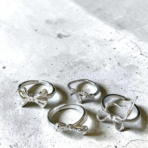 May include: A set of three ceramic mugs with a speckled, matte finish. The mugs are in shades of cream, light gray, and dark gray. Each mug has a simple, minimalist design, perfect for coffee or tea.