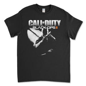 Könnte beinhalten: Ein schwarzes Kurzarm-T-Shirt mit einem weißen Grafikdruck des Call of Duty Black Ops II-Logos und der Silhouette eines Soldaten, der eine Schusswaffe hält. Das Design ist mittig auf der Brust platziert, mit dem Text Call of Duty in Weiß und Black Ops II in Orange.