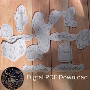 May include: A collection of embroidery patterns on paper featuring a sword, a stag, a bird, a heart with flames, a tombstone labelled Sam, and text phrases including You do not Yield, Rattle the Stars, and To What Ever End. A circular logo reads Thread and Cinder.
