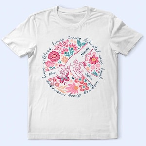 May include: White t-shirt featuring a floral design with two hands holding each other. The design includes the words "Mommy", "Kelvin", and "Sophia", surrounded by floral elements and words like "loving" and "caring".
